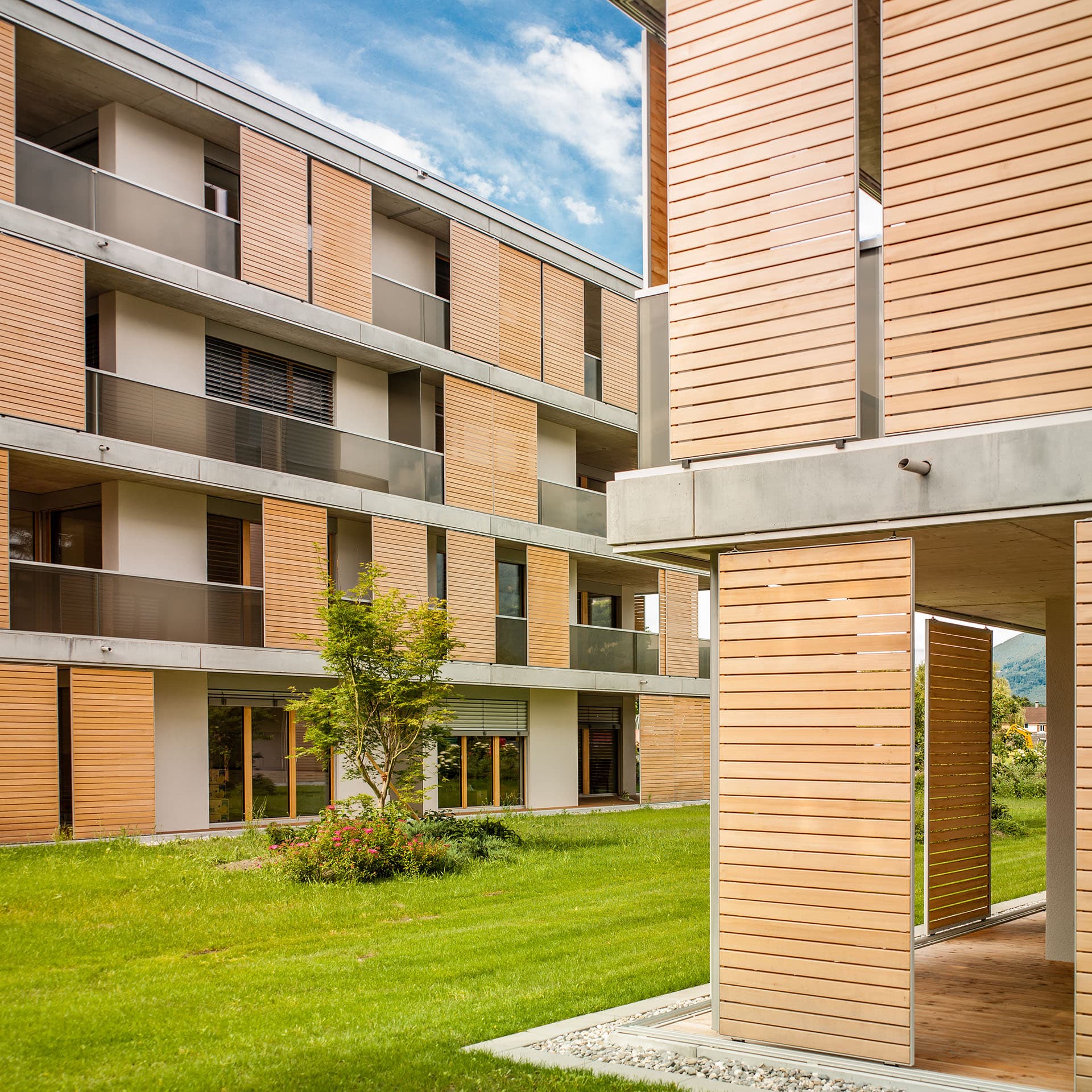 Mehrfamilienhäuser mit Schiebefensterläden aus Holz